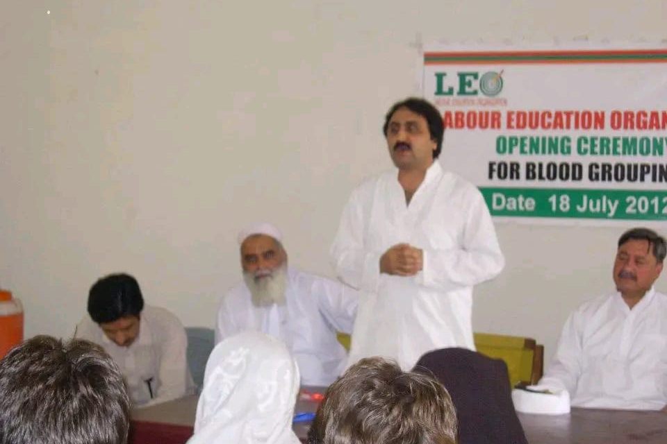 A speaker addresses the audience at LEO's blood grouping centre opening ceremony, beneath a LEO banner dated 18 July 2012